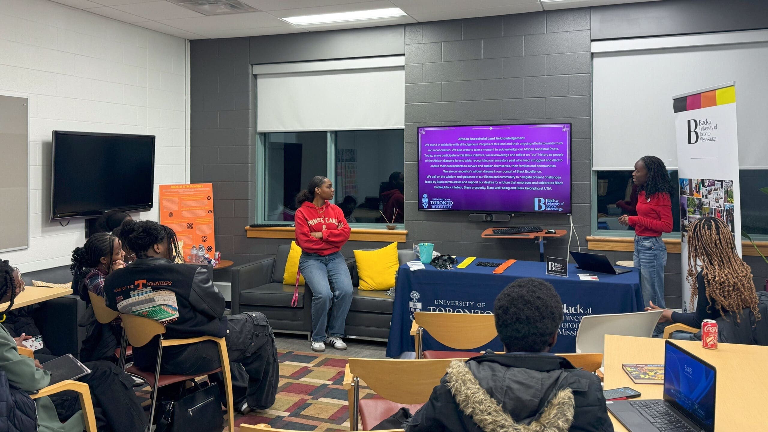Two students standing before a screen in the CBEB giving a presentation